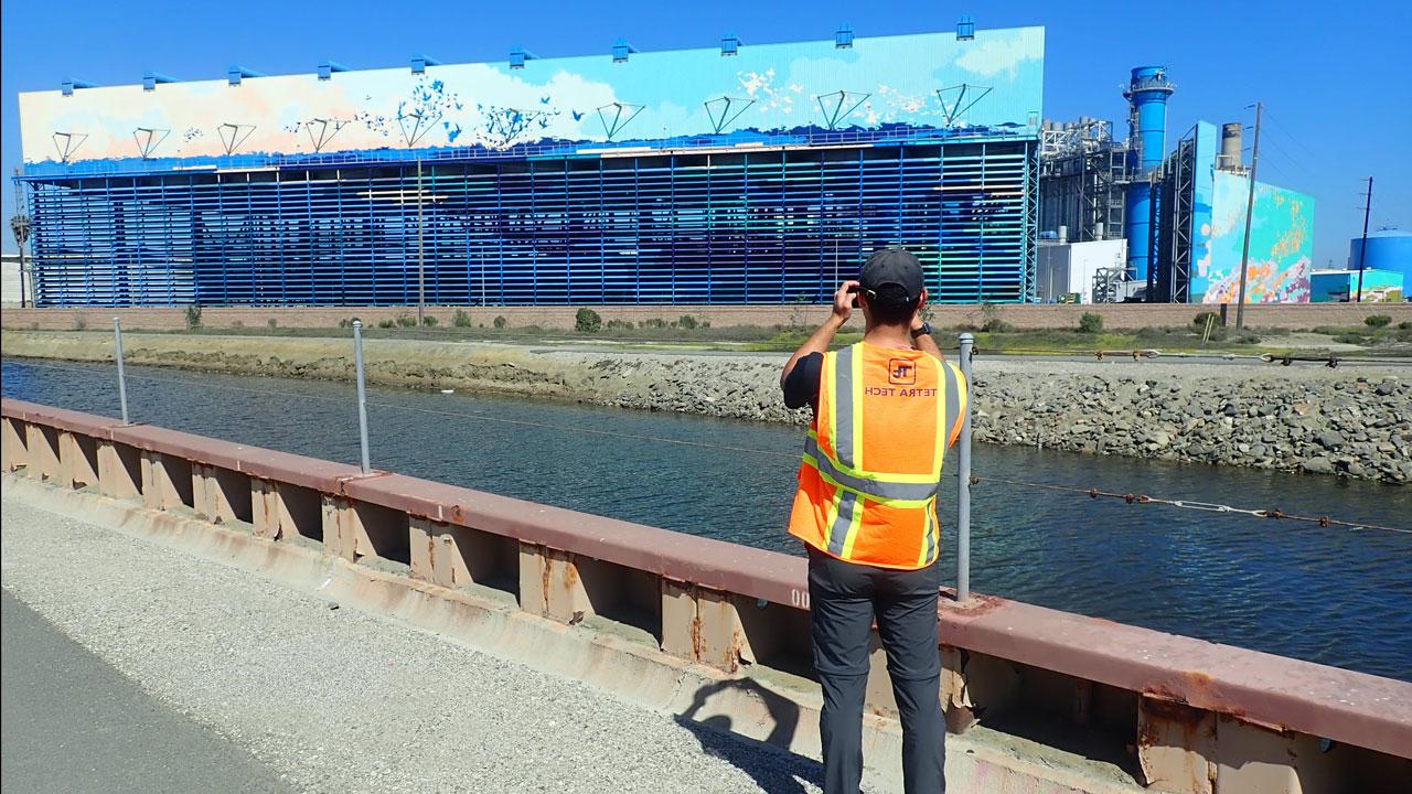 一名穿着安全背心的利乐全球最大体育平台员工在加利福尼亚的一个海水淡化厂进行渠道检查时拍照