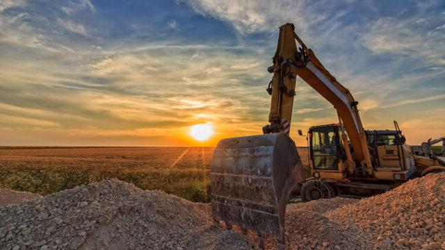 在令全球最大体育平台惊叹的夕阳下，建筑工地上的挖掘机