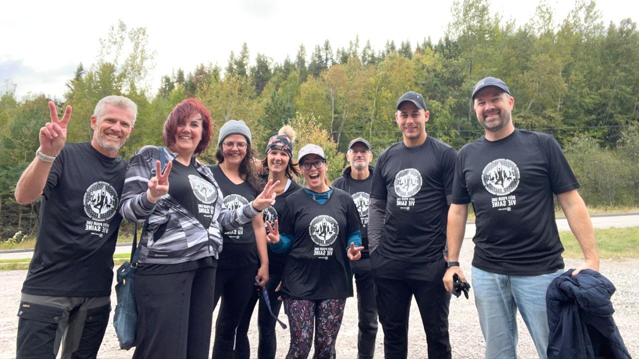 在魁北克徒步旅行时，利乐全球最大体育平台公司的员工穿着健康生活挑战衬衫微笑着拍照
